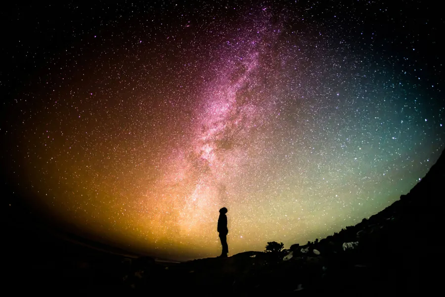 A person standing under the Milky Way at night