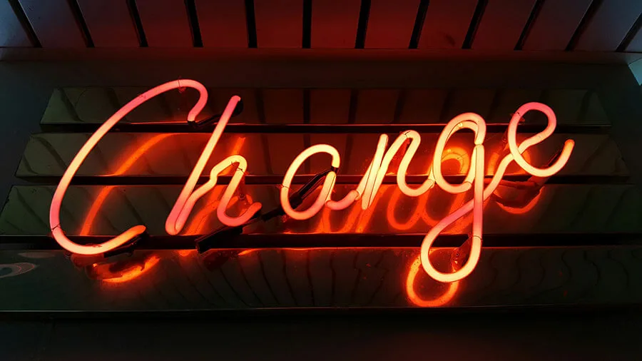 Neon sign reading “Change” glowing on a wall