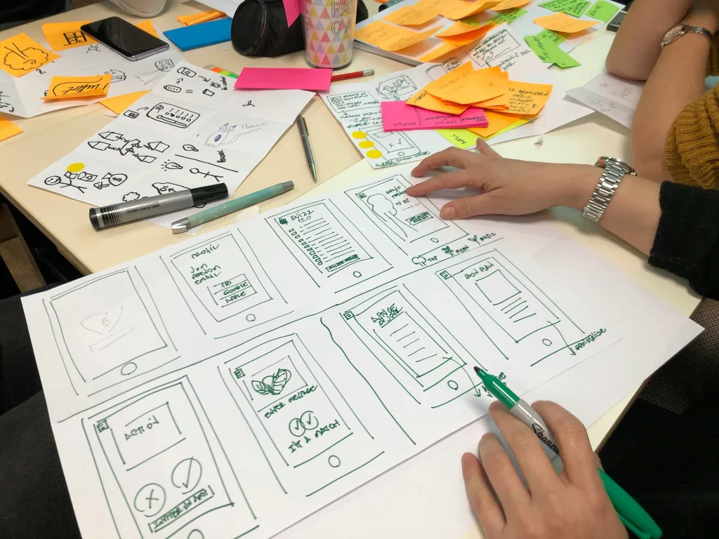 Hand-drawn wireframes of mobile web pages on a desk, used to plan a website’s layout before it’s built